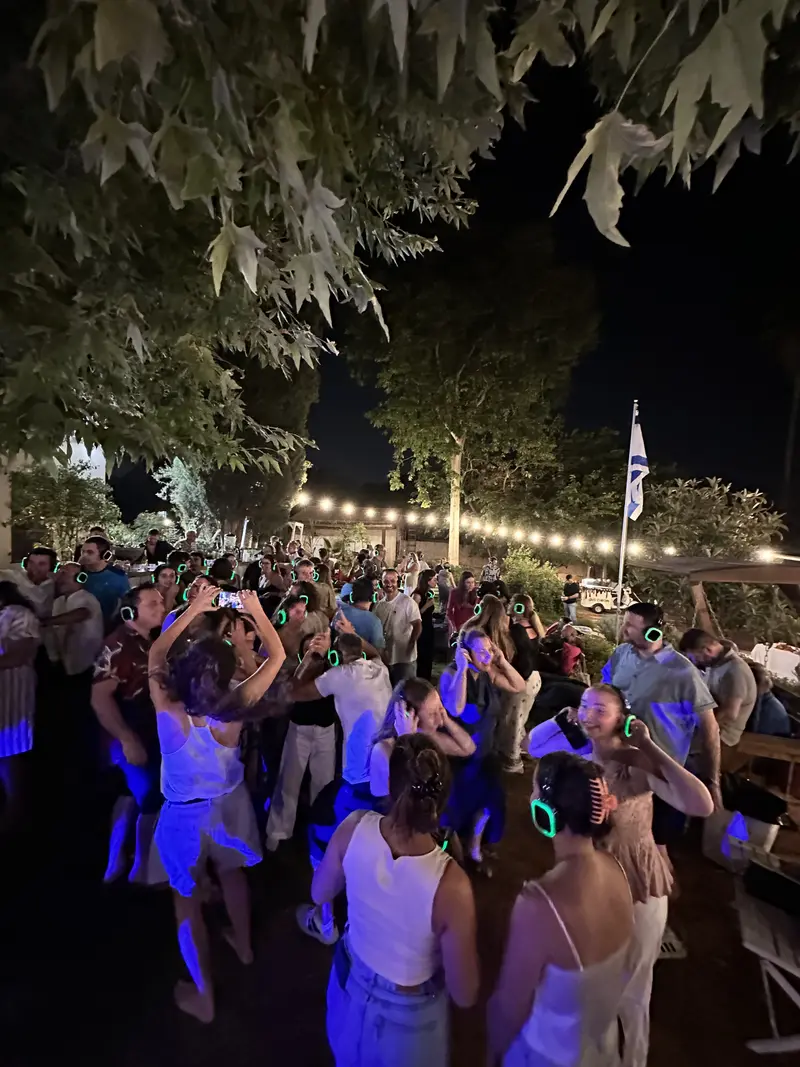 רחבה מלאה באוזניות ירוקות תחת שרשרת נורות
